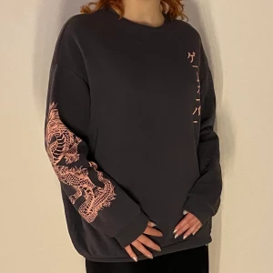 Sweatshirt - Mörkgrå sweatshirt med ljusrosa tryck. gott skick.