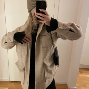 Beige kappa - Säljer den här jättesnygga kappan från NA-KD, ser helt oanvänd ut. Ett band till midjan tillkommer även