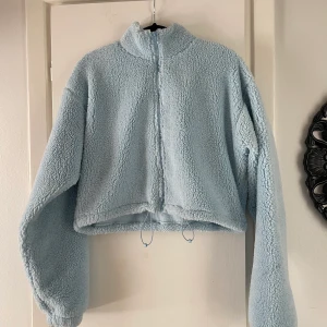 Croppad Teddyjacka strl M - Blå croppad teddyjacka från Nelly i storlek M, oanvänd. 
