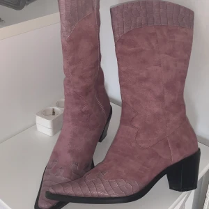 Lila cowboyboots - Lila cowboyboots, nästan helt oanvända, storlek 37. Kan frakta men kan också mötas upp och lämna över i Trollhättan, Mellerud, Uddevalla och Vänersborg.