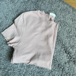 En t-shirt  - En rosa t-shirt från Kappahl. Lite tajt och i storlek 164/xs. Nyskick och använd fåtal gånger 