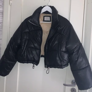 Glansig dunjacka  - Svart glansig dunjacka ifrån Bershka, i nyskick. Storlek xs 