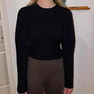 En stickad svart stickat tröja med lite ballongärmar från Gina Tricot strl S