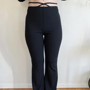 Svarta byxor med snören  - Byxor med snören i midjan från Nelly, storlek S. Lite utsvängda nertill. Använda 1 gång. 