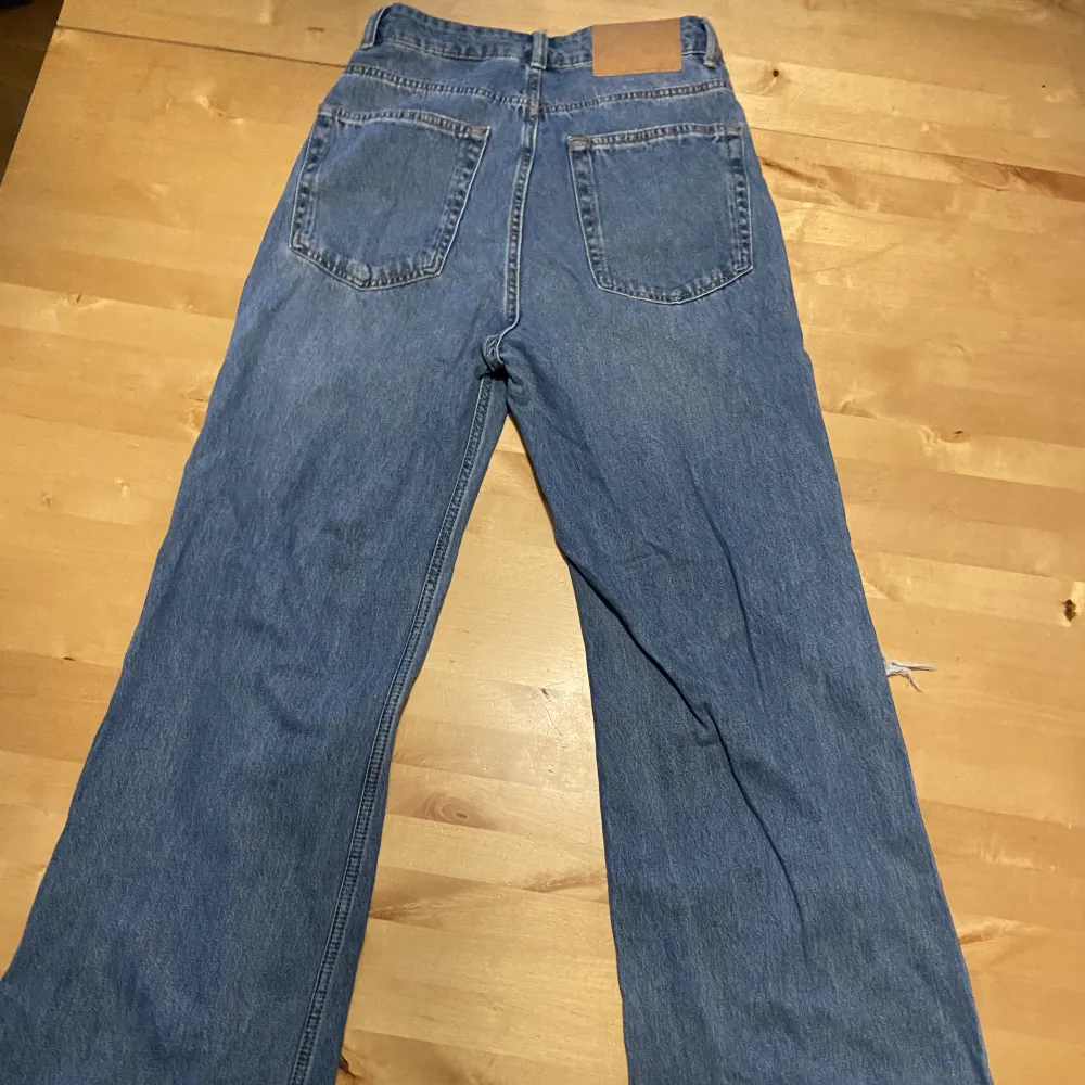 Högmidjade blåa jeans med hål i. Helt oanvända . Jeans & Byxor.