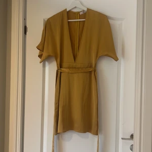 Senapsgul satin klänning - En jätte fin senaps gul satinklönning. Aldrig använd
