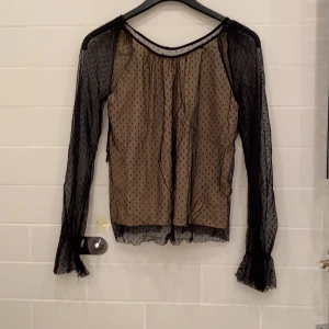 Prickig Mesh Topp - En mycket fin prickig mesh topp med nude lager under, snörs ihop på baksidan. Väldigt fin för att ha på en utekväll!! Aldrig använd. 