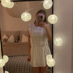 Vit volangklänning från bik bok  - Säljer en vit volang klänning från bikbok. Super fin och i bra skick (använt två gånger). Jag är 168 cm lång. Köparen står för frakt!