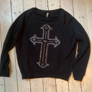 Tröja Med Kors - Super snygg svart långärmad tröja med kors utav diamanter som jag köpt second hand. Säljer pga att den inte kommer till användning. Skriv om ni har frågor💋