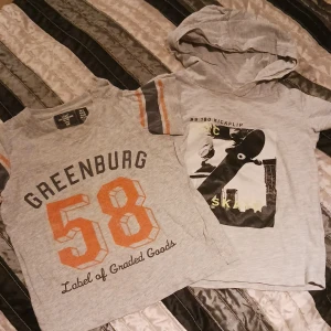 2 t-shirtar barn - 1 grå med skatemotiv i storlek 86 on 1 grå med text i stor storlek 74. Använt skick