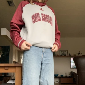 Adidas College Hoodie - Hail Eagles college hoodie från Adidas. Felfri och väldigt bekväm på insidan. Perfekt att ha på sig hemma en bekväm kväll, i skolan eller till träningen. Fråg: Röd och grå. Jag har storlek M i vanliga fall.
