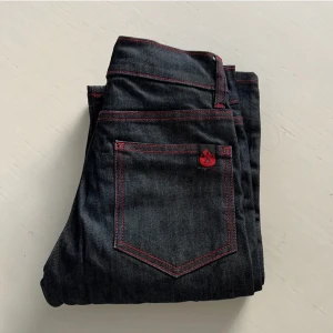 Low waisted jeans - Snygga vanliga jeans med röd söm som får dem att inte se så super basic ut, långa i benen, low waist. Står att det ör storlek 27 men skulle passa 26 köptes för 400kr  mera  !lånade bilder! Skriv om frågor,
