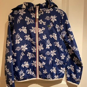 Lacoste barns jacka -  Jag säljer denna snygg flickors höst/vår regnjacka jacka från Lacoste. Konditionen är som ny. Den säljas för 250kr men den nya är runt 700kr. Köparna står för frakt❤️