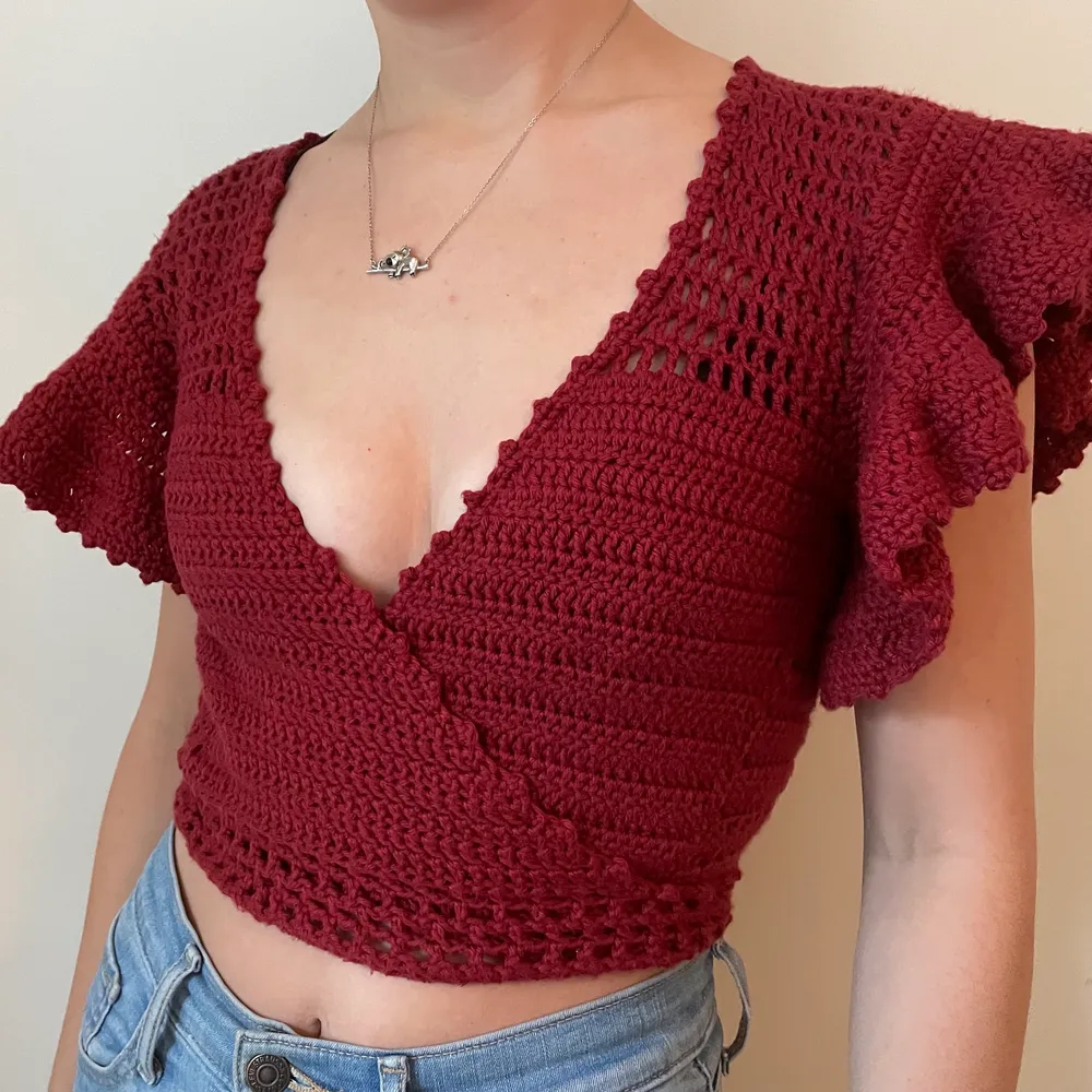 handmade wrap top, crocheted from 100% maroon/red soft cotton yarn (sourced in sweden). beautiful details: flared sleeves, textured edges, wrap around with tie in the back, mesh additions. the wrap around design allows it to fit different sizes. . Toppar.