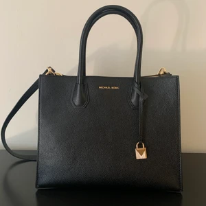 Michael Kors väska  - Säljer en superfin Michael Kors Mercer Tote väska som är i nyskick. Väskan är använd max 2 gånger. Väskan är i äkta skinn, den har gulddetaljer och har en justerbar axelrem. Med väskan medföljer en dustbag. Storlek: Längd 32 cm, bredd 14 cm, höjd 25 cm. 