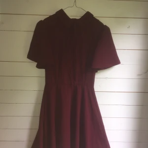 Retro dress klänning röd red Shein - I’m selling my beautiful dark red dress (from Shein, size 34). It’s a nice retro look which makes a great figure because of the waist seam. High neck with a nice plain ribbon, it’s in a very good condition and was only worn once for a photoshoot
