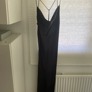 Svart satinklänning - Säljer en oanvänd svart satinklänning strl. M från GinaTricot. Fin dekoration baktill på ryggen.🖤