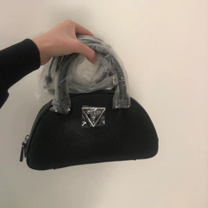 Guess väska - En ny guess väska, köpt i guess affär och aldrig använd. Svart med silverdetaljer. Alla lappar kvar. Nypris: 1000kr, säljer för 800kr