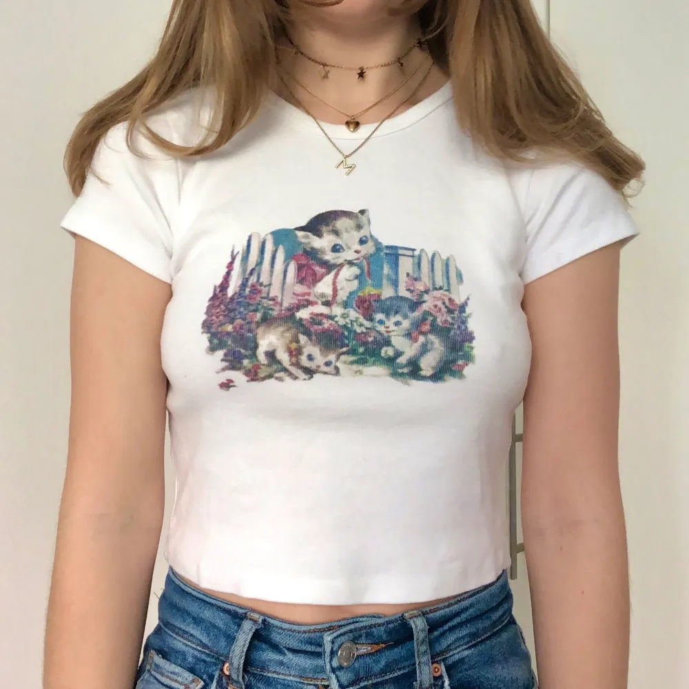 Topp/t-shirt med katt tryck från Brandy Melville 🐈 Använd fåtal gånger så är i mycket bra skick ☘️ Ingen storlek står men uppskattas till XS-S . T-shirts.