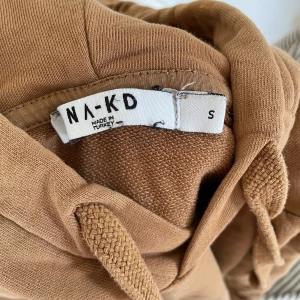Hoodie - En fin brun hoodie från NA-KD. Strl S. Nästan aldrig använd. Inga defekter. Köparen står för frakten. ⚠️Det finns katter i huset⚠️