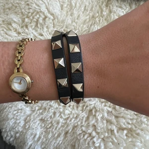 Valentino Garavani  - Säljer mitt super fina valentino armband. Det är i fint skick, dock har det lilla spännet lossnat så att sista biten av armbandet ”hänger löst” ( syns på bild 2) därav lägre pris. Man kan fixa det genom att sätta ett genomskinligt gummiband där :) har kvitto, påse & låda kvar! Köpt på MyTheresa