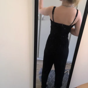 Svart byxdress  - Svart byxdress i storlek 38 men är väldigt liten men samtidigt väldigt stretchig. Jag har använt den innan och jag har 32/34 på mina kläder. Använd fåtal gånger. Mjukt och svalt material till sommaren.