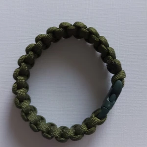 Armband av makrame  - Har gjort den själv av starkt militärgrön 4mm cord  Låset är av plast, armbandet är 21cm  Bredden 18mm  Gör även med lås av stål  Kan beställas för rätt passform Porto 13kr 