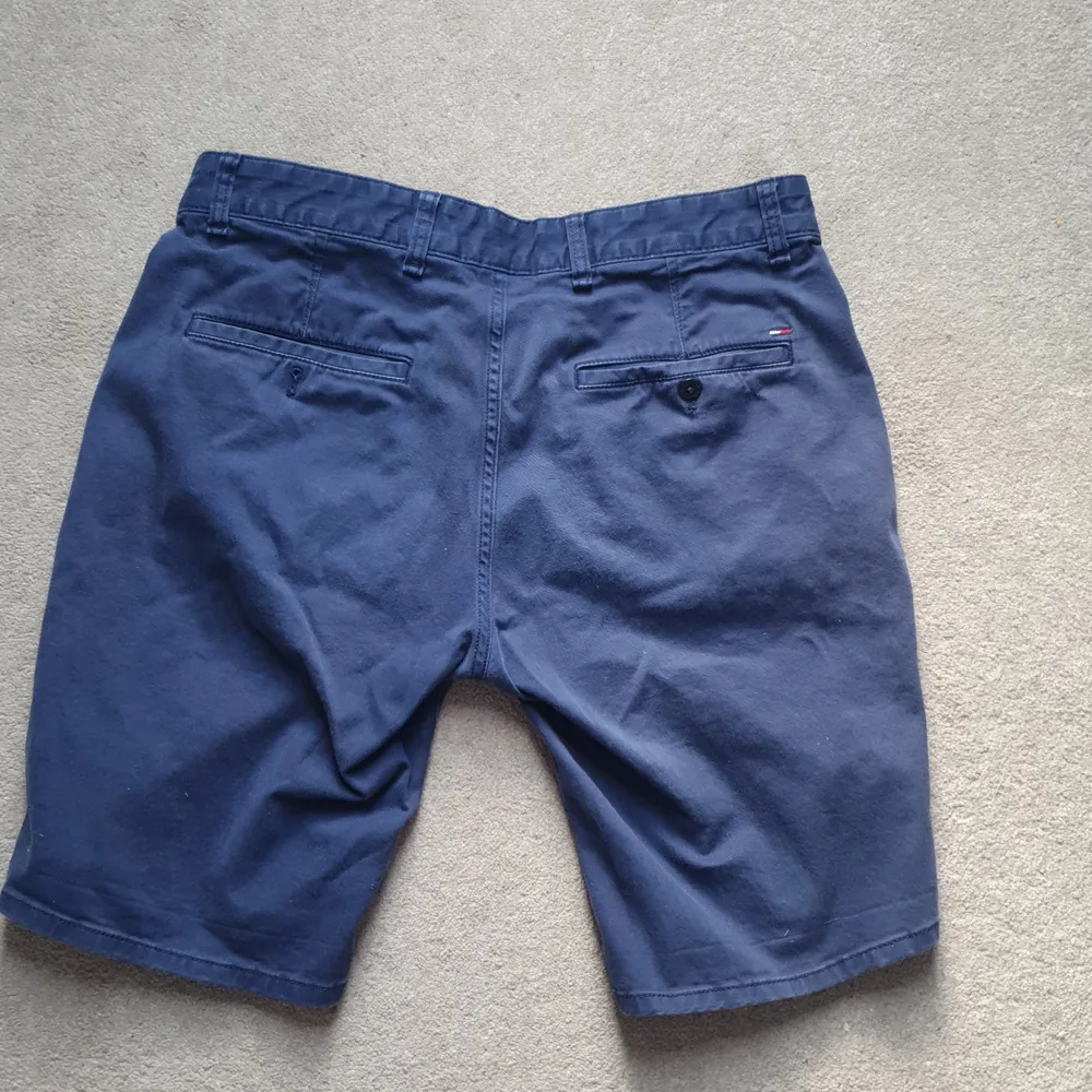 Marinblå shorts i storlek 33, solblekta men hela av hög kvalité.. Shorts.