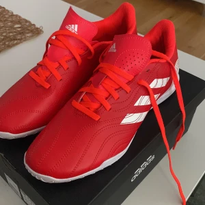 Gympaskor - Ett par röd/ oranga gympa skor. I märket adidas. Kanske använt 1gång. Storlek:41 och en halv.