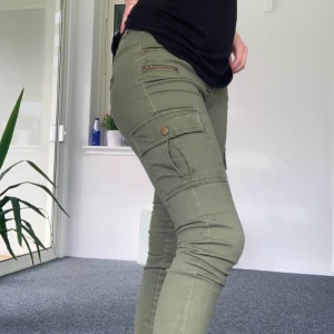 Lågmidjade cargopants - Snygga cargobyxor med låg midja. Lagom stretch i tyget vilket gör att de sitter perfekt på benen! De är i fint skick och har mycket mer att ge. Storlek 28/32 vilket kan ses som ungefär en small 