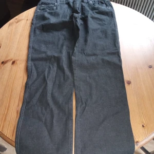 Damjeans svarta med resår i midjan .stl 44/48. - Damjeans Jonna B svarta med resår i midjan och knäppes med knappar och dragkedja fram. Nyskick .Inget slitage finnes .hämtas i Skene alt skickas o köpare betalar frakten o Swishbetalning tillämpas .frakt inräknat i priset .(104).