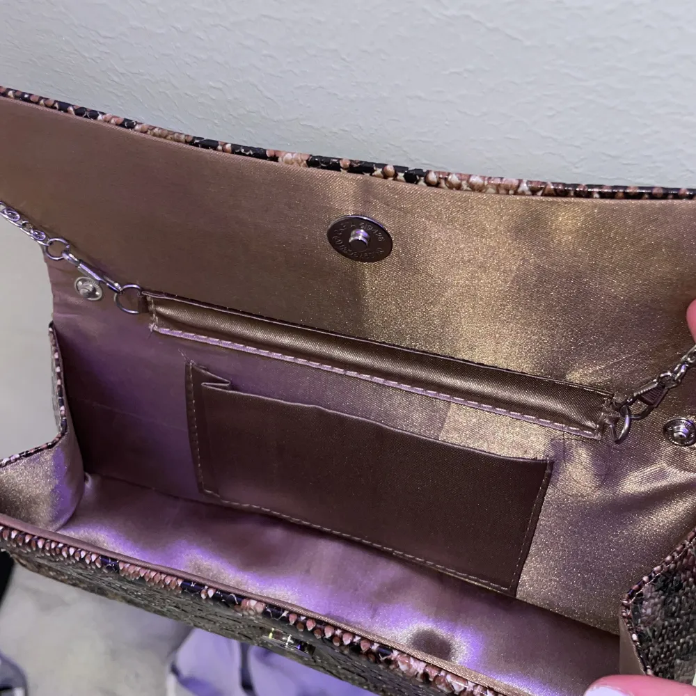 En liten ormmönstrad festväska med en snygg detalj på, ser gott som ny ut och har inga fel!. Väskor.