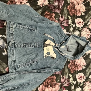 Märkes denim bomberjacka  - Mycket fin denim bomberjacka från Bershka, med Snobben tryck.  Storlek M med etikett på, helt oanvänd. 