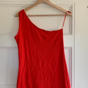 Kort Röd Klänning One Shoulder - En kort röd klänning ifrån HM storlek 38/Medium. Den är one shoulder, aldrig använd. 100kr + frakt (cirka 50 kr) 