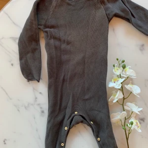 Sparkdräkt brun strl 92 nyskick - Nästintill ny sparkdräkt endast använd två ggr. Tyvärr fått någon färgskiftning på överdelen av framsidan som syns på bild.  Brun med träknappar, storlek 92. 