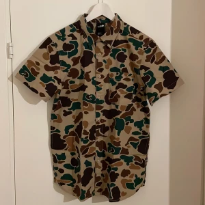 The North Face skjorta - Kortärmad camouflage skjorta i luftig bomull. Regular fit. Oanvänd. 