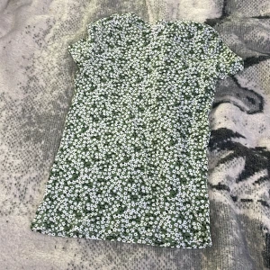 En grön tröja med vita blommor på - En grön tröja med vita blommor på i storlek xs jätte fin o bekväm knappt använd 