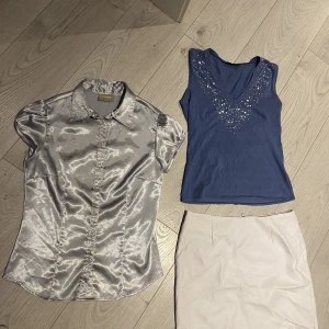 Y2K-kläder  - Ett riktigt litet y2k-paket!! Silvrig topp, en knapp fattas men enligt mig gör det ingenting, syns inte. Annars kan man lätt fixa det. Kjolen är i fejkskinn och linnet hade min mamma på 90-talet. Hur nice? Kjolen är s, silvertopp xs och linnet xs/s. 