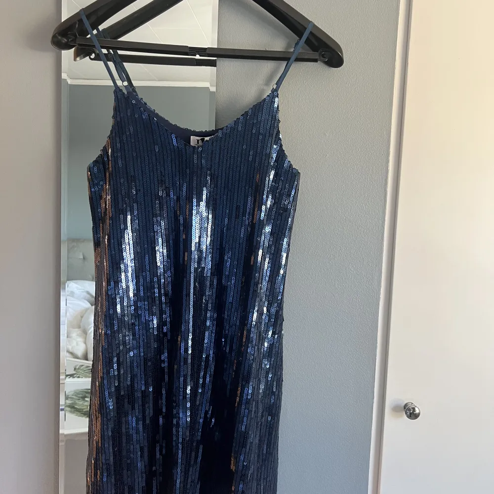 Säljer en blå glittrig klänning från Linn Ahlborg x NA-KD i storlek 32, stor i storleken. Aldrig använd med lapp kvar. Köpt för kanske 2 år sedan. . Klänningar.