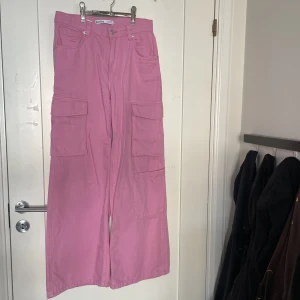 Rosa cargopants - Rosa cargobyxor från Bershka. Obs de är inte fläckiga, det är skuggor från ljuset! Jättefina och sparsamt använda, säljer pga tyvärr försmå på mig (172cm). (Läs i min bio för mer info). 