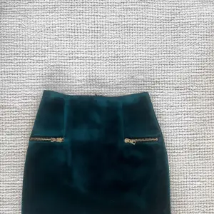 Mörkgrön kjol från Sandro i storlek 2. Guldiga detaljer.