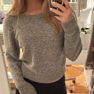 Grå Stickad tröja - Supersnygg och jätteskön grå stickad tröja från Samsøe Samsøe. Sparsamt använd och perfekt till vintern då den är varm och skön. Passar XS/S. Nypris runt 1000 kr. Frakt på 60 kr ingår i priset därför lite högre pris än vanligt!!