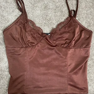 Topp från bilbok - Knappt använd topp från Bikbok Silk material, väldigt mjuk Brun Storlek M men sitter som en S