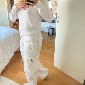 Cargobyxor - Säljer mina sjukt snygga vita caropants som tyvärr inte används tillräckligt. Midjemåttet är ca 80 cm, men det går att justera till ett mindre mått, tack vare ett inbygt skärp i byxan. Innerbenslängden är ca 77 cm.