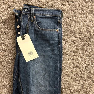 Levis jeans med lapp kvar - Ett par helt nya Levis jeans med lappen kvar, modell ”skinny” Mörkblåa med supersnygga detaljer 