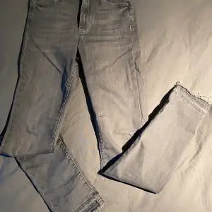 Grå jeans i skinny modell  och med sliten och fransig kant nertill H&M, Denim