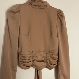 Festtopp - Super fin topp med puffärm och knyte i ryggen. Även veck på både övre och nedre del av toppen.  Verkligen så fin men kommer inte till användning💛