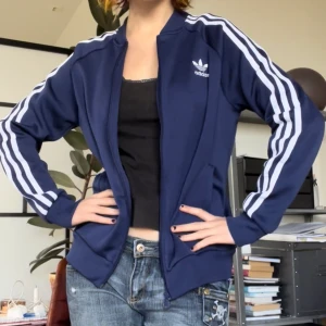 Adidas munkjacka - Snygg mörkblå adidas jacka/kofta! Jag på bilden bär oftast en S men den passar nog upp till M beroende på hur man vill att den ska sitta🫶 Hör av dig vid frågor <3