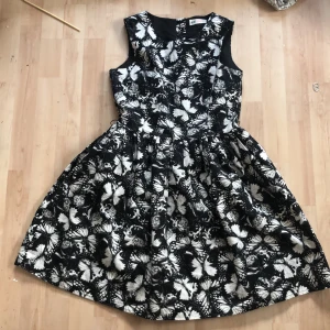 Klänning med fjärilar - En svart klänning med vita fjärilar  Fint skick  Knappt använd  Säljs pga att jag använder den aldrig  