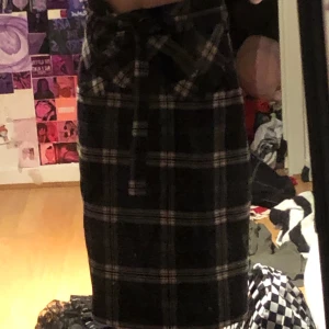 Svart rutig kjol - En svart kjol med vita ränder fin kvalitet  Knappt använd  Snörre för att spänna in även dragkedja  Ordinarie pris ligger mellan200-400kr Säljer pga använder den inte 